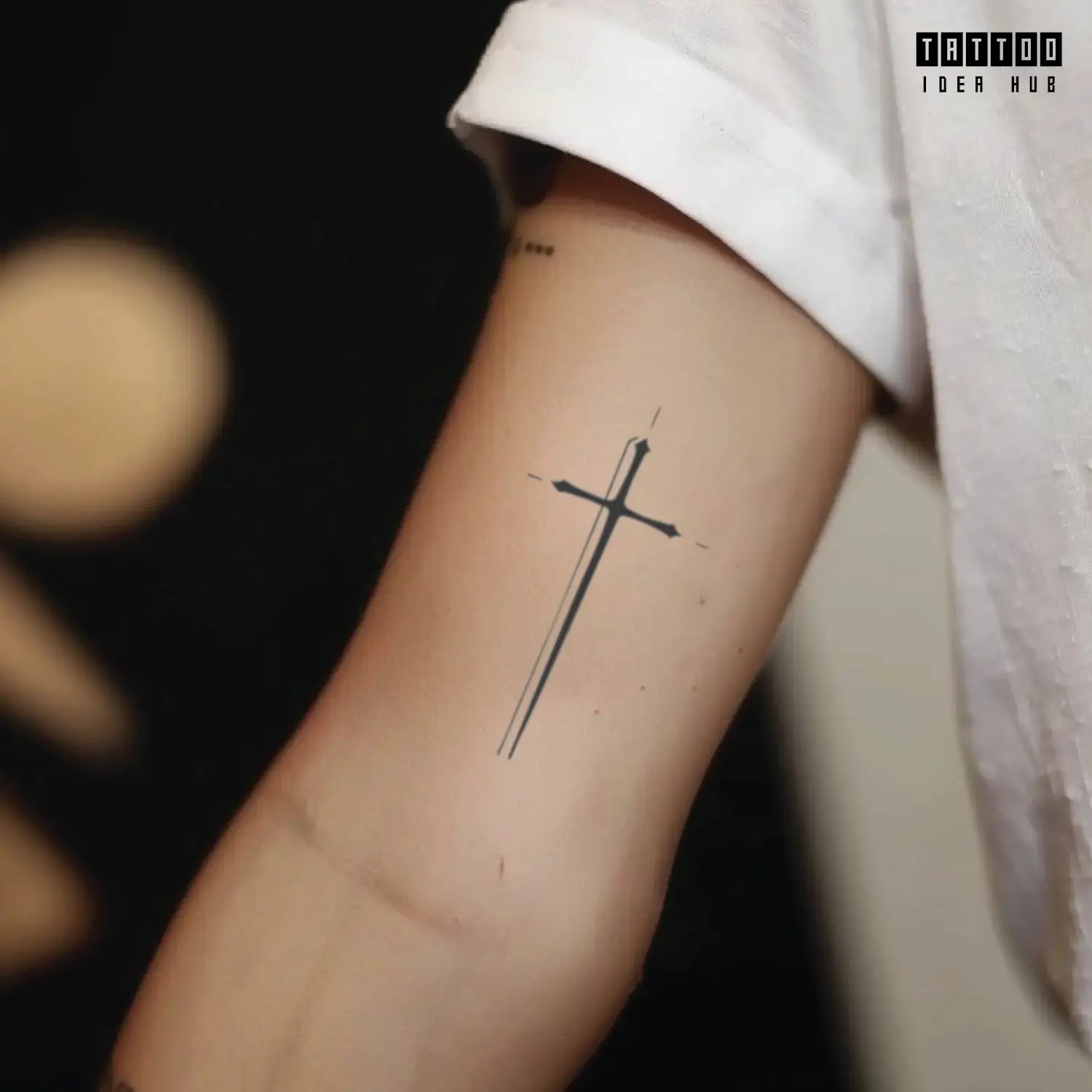 minimal fine line cross bicep temporary tattoo idea design